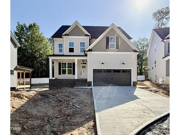 Charming two-story home with a two-car garage and inviting front porch on a sunny day at 2617 Silver Gate Ct, Wake Forest, NC 27587