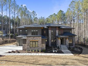 Stunning modern home with stone accents and a landscaped yard at 7640 Falls Creek Ln, Raleigh, NC 27614