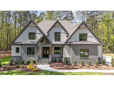 Charming gray home featuring a mixed material facade and professionally landscaped front yard at 330 Hidden Lake Dr, Youngsville, NC 27596