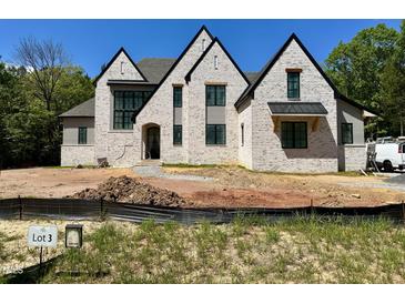 Stunning new construction home featuring a light brick exterior and black trim at 65 Firefly Overlook, Pittsboro, NC 27312