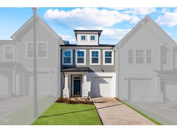 Beautiful townhome with manicured lawn and a driveway leading to an attached garage at 553 Eversden Dr, Zebulon, NC 27597