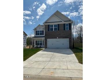 Two-story home with brick and siding, a two-car garage and long concrete driveway at 253 Plains Dr # 264, Burlington, NC 27217
