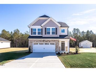 Two-story house with gray siding, stone accents, and a white garage door at 211 Wild Turkey Way, Lillington, NC 27546
