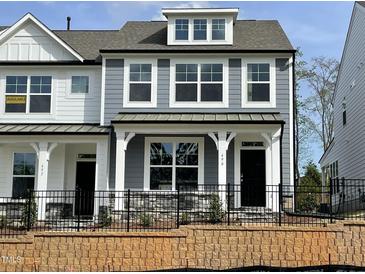 Charming two-story home featuring a stylish mix of light gray and white siding and black wrought iron fencing at 490 Traditions Grande Blvd # 27, Wake Forest, NC 27587