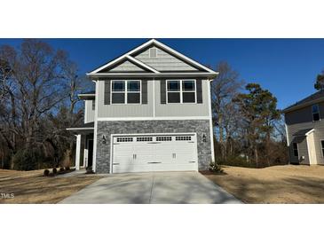 Two-story home with gray siding, stone accents, and a two-car garage at 211 Hopewell Branch Ct, Smithfield, NC 27577