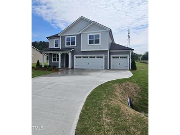 Two-story home with a two-car garage, concrete driveway, and well-manicured front lawn at 104 Gin Branch Rd, Wendell, NC 27591