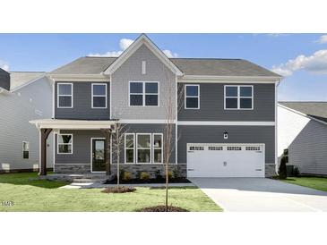 Charming two-story home with a gray facade, well-manicured lawn, and a two-car garage at 1301 Jasmine View Way, Knightdale, NC 27545