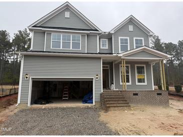 Two-story home showcasing a gray exterior, inviting front porch, and a convenient two-car garage at 135 Green Haven Blvd # 1, Youngsville, NC 27596