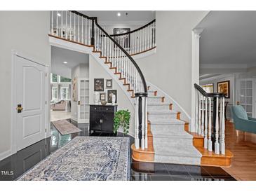 Grand foyer with winding staircase, black tile floor, and stylish decor at 4600 Scottland Dr, Mebane, NC 27302