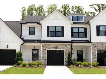 Charming townhome with white siding, black shutters, stone accents, and well-manicured lawn at 727 Putney Hill Rd, Zebulon, NC 27597
