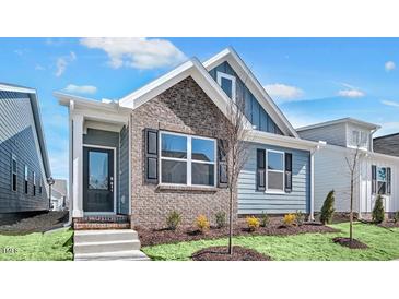 Charming two-story home with blue siding, brick accents, and a well-manicured front yard at 1304 Jasmine View Way, Knightdale, NC 27545