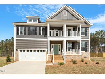Charming two-story home with a covered porch, attached garage, and neutral color palette at 80 Bold Dr, Youngsville, NC 27596