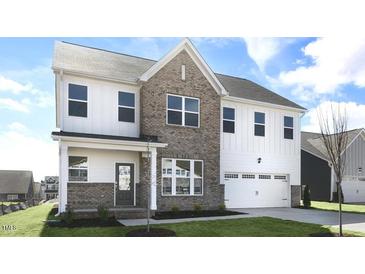 New two story construction featuring brick and light siding with an attached two car garage at 512 Lemon Daisy Ln, Knightdale, NC 27545