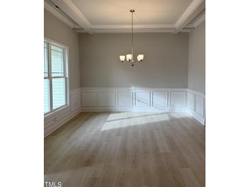 Bright dining room featuring a modern chandelier, wainscoting, and hardwood floors at 105 Watermelon Dr, Franklinton, NC 27525