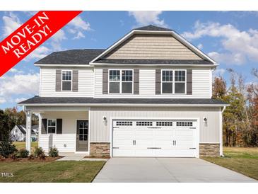 Move-in ready two-story house with a large white garage door and landscaping at 246 Trescott St, Smithfield, NC 27577