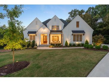Charming white brick home featuring a landscaped front yard and inviting front porch at 60 Citori Ct, Pittsboro, NC 27312