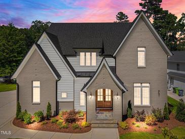 Stunning two-story home with a brick and siding exterior, complemented by lush landscaping and a welcoming entrance at 701 Dartmouth Rd, Raleigh, NC 27609