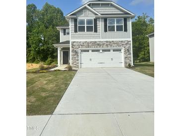 Charming two-story home featuring a stone facade and a spacious two-car garage at 321 Hopewell Branch Ct, Smithfield, NC 27577