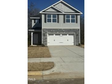 Two-story house with gray siding, stone accents, and a two-car garage at 347 Hopewell Branch Ct, Smithfield, NC 27577