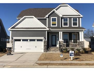 Charming two-story home with a gray exterior, white trim, and a two-car garage on a sunny day at 1528 Maelyn Way, Fuquay Varina, NC 27526