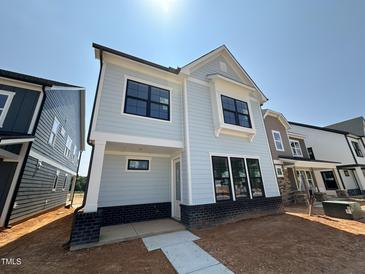 Charming two-story home featuring a light blue facade, black framed windows and modern architectural details at 2408 Adrift Road, Fuquay Varina, NC 27526