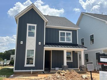 Stylish two-story home featuring modern vertical siding, white trim, and a welcoming front porch, still under construction at 2412 Adrift Road, Fuquay Varina, NC 27526