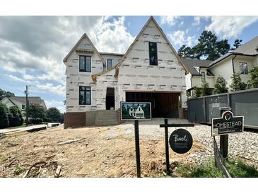 Two-story home under construction showing the initial framing and brickwork details against a partly cloudy sky at 3301 Dell Dr, Raleigh, NC 27609
