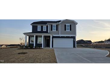 Charming two-story home boasts a two-car garage and inviting front porch at 111 Brodhead Dr, Fuquay Varina, NC 27526