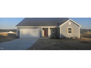 Charming single-story home with gray siding, a two-car garage, and a well-manicured lawn at 159 Robert Howe Dr, Fuquay Varina, NC 27526