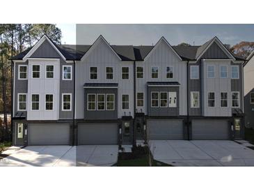 Contemporary townhouses with gray siding, white accents, and attached garages at 2126 Opulent Oaks Ln # 14, Durham, NC 27713