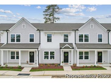 Charming townhome exterior featuring gray siding, black doors, and beautifully landscaped front yards at 156 Camel Crazies Pl # 35, Lillington, NC 27546