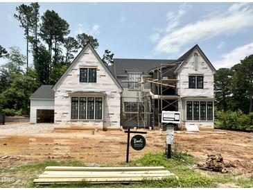 Stunning new construction home featuring a modern design with black windows and a light-colored facade at 7000 North Ridge Dr, Raleigh, NC 27615