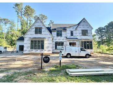 View of new construction home with modern farmhouse design, featuring large windows and covered porch at 7000 North Ridge Dr, Raleigh, NC 27615