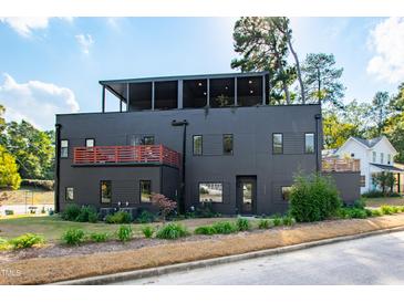 Modern three-story home with a black exterior, rooftop patio, and professionally landscaped front yard at 1511 Malta Ave, Raleigh, NC 27610