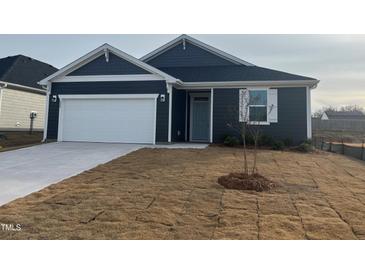 New construction home with gray siding, white garage door, and landscaping at 222 Chestnut Oak Ln, Lillington, NC 27546