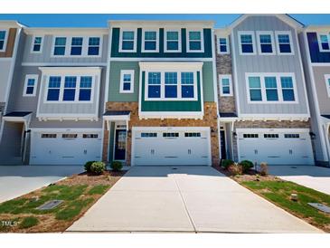 Townhome exterior showcasing modern architecture, stone accents, and attached garages at 2337 Bay Minette Sta # 553, Apex, NC 27502