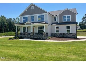 Charming two-story home with a manicured lawn and classic architectural details at 23 Quail Pt Cir, Clayton, NC 27520
