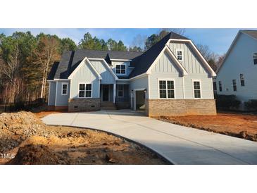 Charming two-story home featuring a light blue exterior, brick accents, and an attached two-car garage at 846 Cabin Creek Crk, Pittsboro, NC 27312