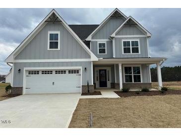 Charming two-story home with gray siding, white trim, a two-car garage, and a well-manicured lawn at 443 Ravensworth Dr, Garner, NC 27529