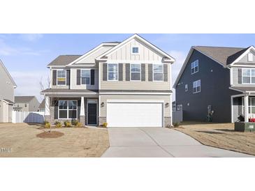 Two-story house with neutral siding and a white garage door, offering curb appeal at 1519 Peabody Ct, Mebane, NC 27302