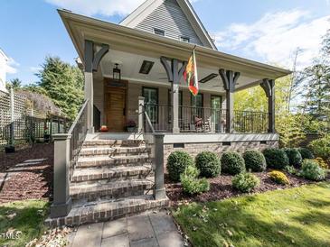 Inviting front porch with brick steps, iron railings, and a charming wood door at 3108 Agecroft Rd, Raleigh, NC 27608