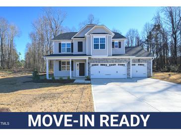 Move-in ready two-story home with gray siding, stone accents, and a three-car garage at 49 Abingdon Farms Dr, Selma, NC 27576