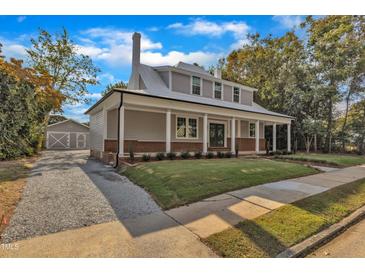 Stunning two-story home boasts a metal roof, brick accents, inviting front porch, and detached garage at 505 S Magnolia Ave, Dunn, NC 28334