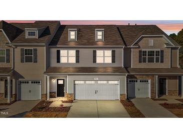 Tan three-story townhome with white garage doors and landscaping at 806 Pryor St # 50, Mebane, NC 27302