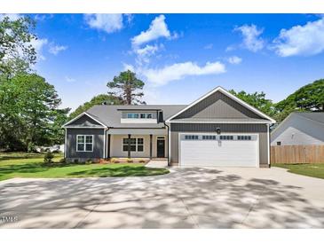 Charming home with a two-car garage, nicely landscaped yard, and a beautiful cloudscape above at 6965 Us-401, Fuquay Varina, NC 27526