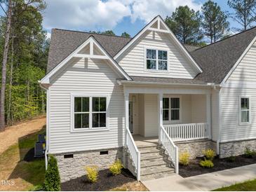 Charming home with stone accents, white siding, landscaped yard, and a welcoming front porch with stone steps at 205 Purslane Dr, Franklinton, NC 27525