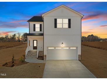 Two-story white house with gray roof, stone accents, and a two-car garage at 35 Diamond Creek Dr, Zebulon, NC 27597