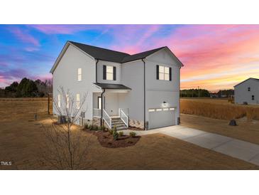 Charming two-story home featuring vinyl siding, black shutters, a welcoming front porch, and an attached garage at 35 Diamond Creek Dr, Zebulon, NC 27597