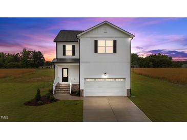 Two-story home showcasing a white exterior, black shutters, and a neatly manicured lawn against a colorful dusk sky at 35 Diamond Creek Dr, Zebulon, NC 27597