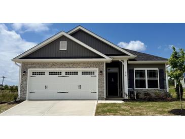 Beautiful home featuring a stone facade and a white garage door with decorative hardware at 214 Drayton Hall Ln, Sanford, NC 27330